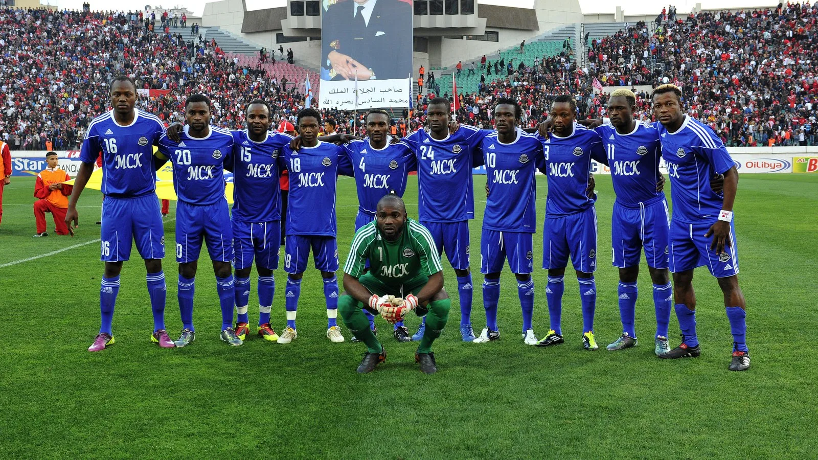 Une équipe du TP Mazembe réunie sur une pelouse avant un match.